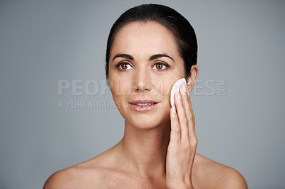 Buy stock photo Mature woman, pad and clean in studio, skin care and facial treatment on gray background. Female person, cotton and swab for grooming in daily routine, mockup space and dermatology to remove makeup