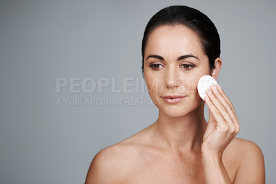 Buy stock photo Mature woman, pad and cleanse in studio, skin care and facial treatment on gray background. Female person, cotton and swab for grooming in daily routine, mockup space and dermatology to remove makeup