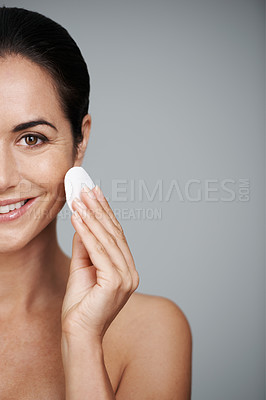Buy stock photo Mature woman, pad and portrait in studio, skin care and facial treatment on gray background. Female person, cotton and swab for grooming on half face, mockup space and dermatology to remove makeup