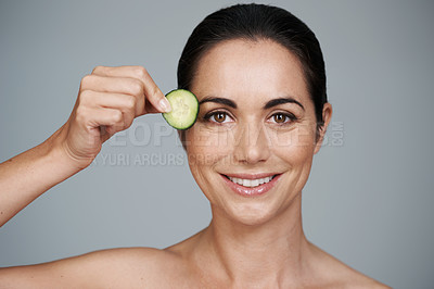 Buy stock photo Portrait, beauty and cucumber with smile of woman in studio on gray background for natural wellness. Face, antiaging or detox and happy mature model with vegetable slice for diet, health or nutrition