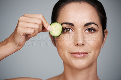 Buy stock photo Portrait, beauty and cucumber for detox with woman in studio isolated on gray background for wellness. Face, skincare or antiaging routine and mature person with slice of fruit for dermatology
