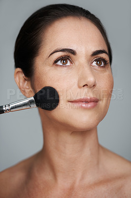 Buy stock photo Cosmetics, brush and mature woman in studio with beauty, natural and facial glow routine. Makeup, self care and confident female person with cosmetology tool for glow isolated by gray background.