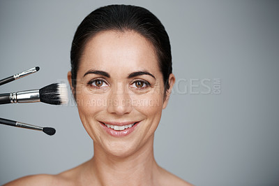 Buy stock photo Makeup brushes, smile and portrait of woman in studio with beauty, natural and facial glow routine. Cosmetics, self care and mature female person with cosmetology tools by gray background with mockup