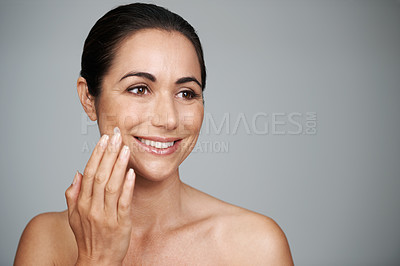 Buy stock photo Face cream, beauty and mature woman in studio for skincare, natural and face treatment. Smile, cosmetic and female person with spf, lotion or sunscreen for dermatology routine by gray background.