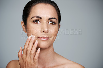 Buy stock photo Portrait, woman and apply cream for skincare or moisturizer in studio isolated on a gray background. Face, cosmetics and mature model with lotion for dermatology, beauty and hydration for anti aging