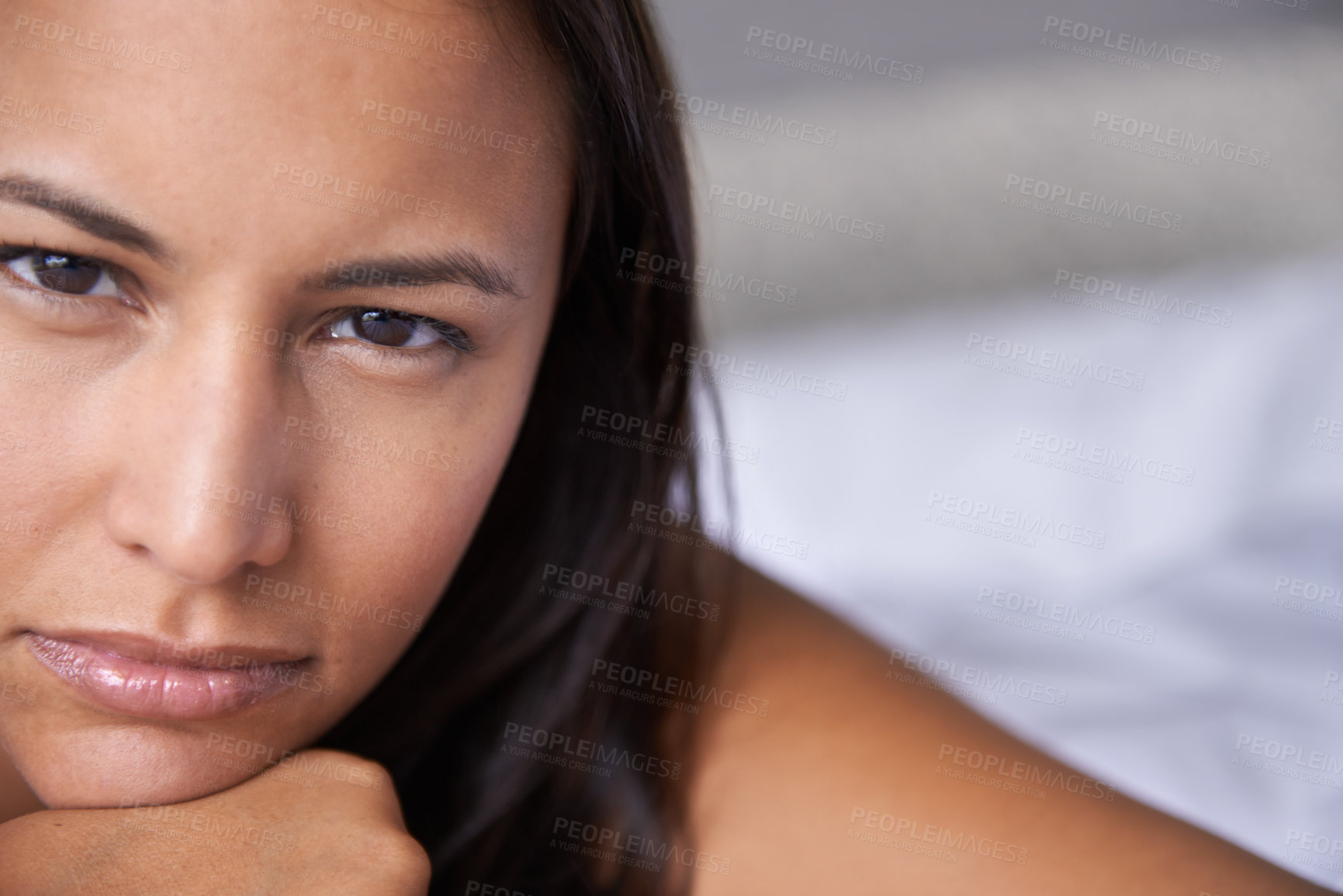 Buy stock photo Closeup portrait of an attractive young woman lying on a bed