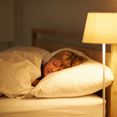 Buy stock photo Shot of a young boy sleeping in bed