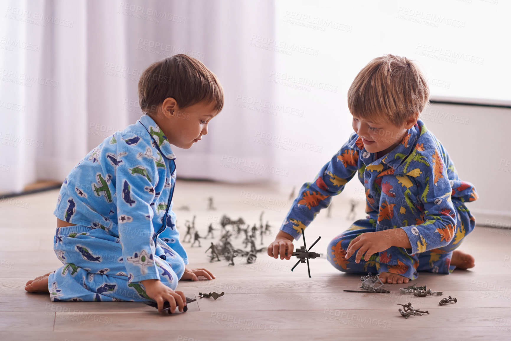Buy stock photo Shot of two brothers playing together in their bedroom