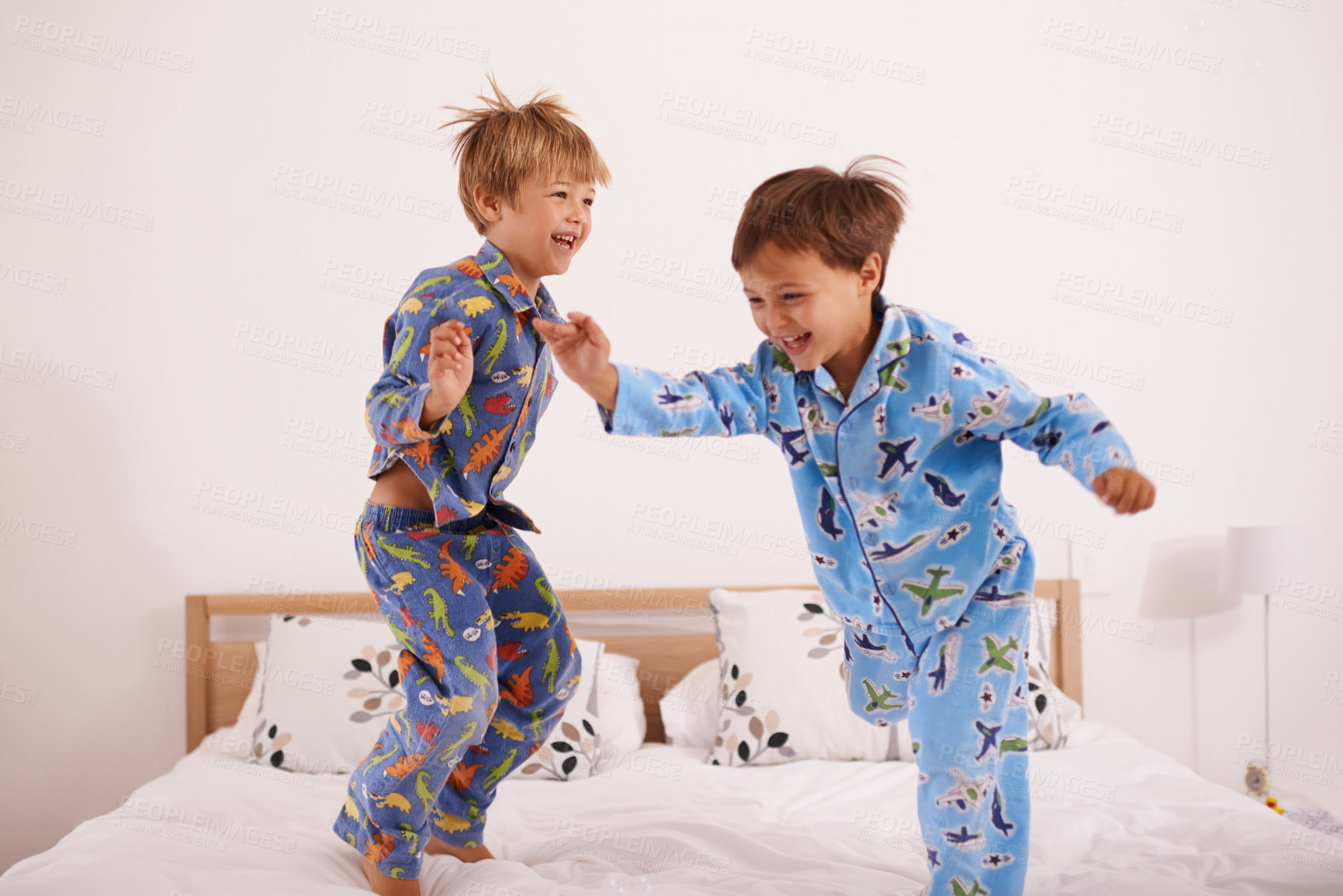 Buy stock photo Shot of two little boys jumping on the bed