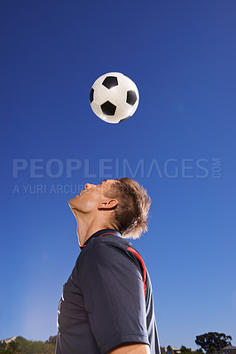 Buy stock photo Football, bounce and head with man, training and technique with competition and exercise. Person, blue sky and player with practice for a game or athlete with skills and sports with fitness or soccer