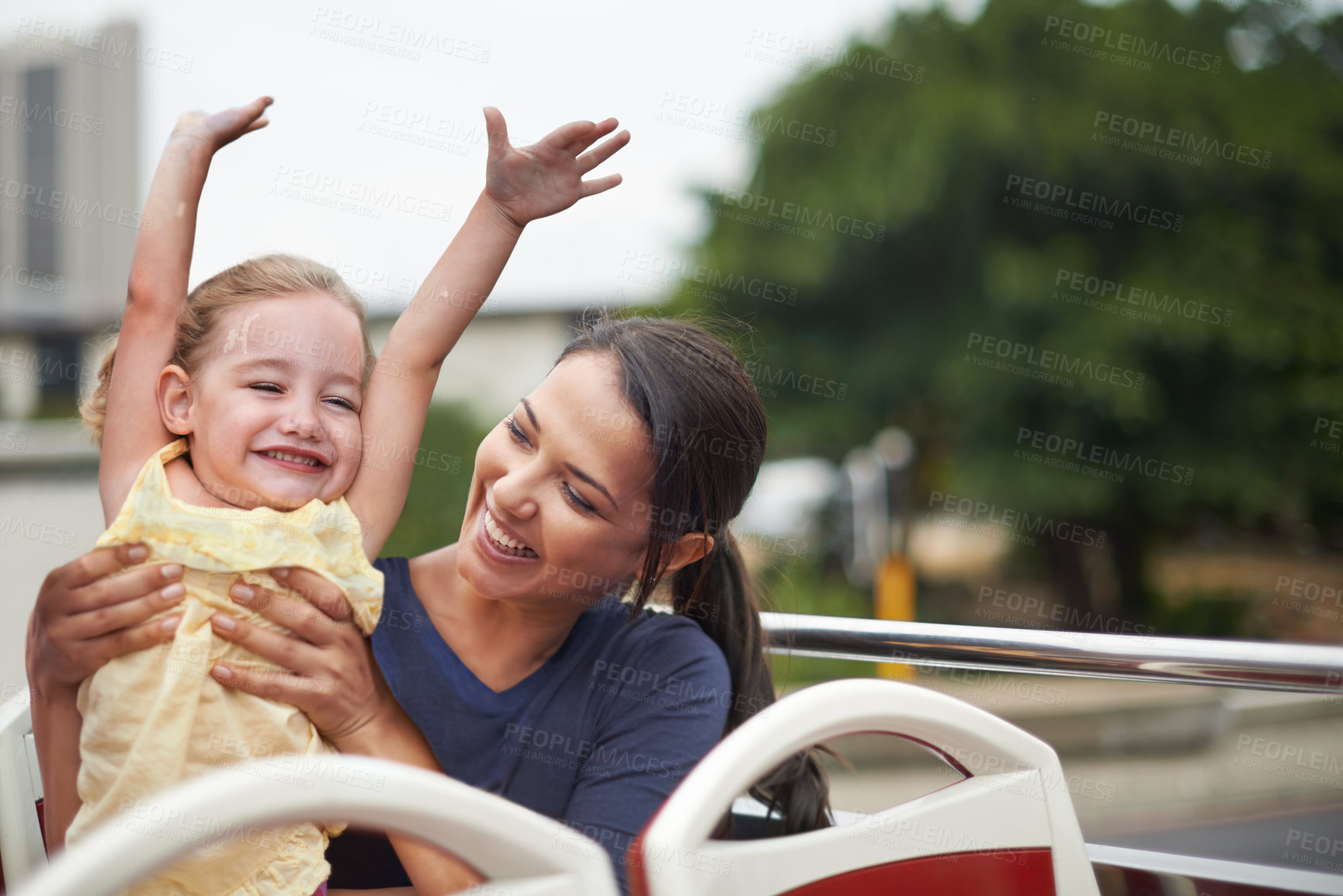 Buy stock photo Shot of a mother holding on to her playful daughter while sitting on the bus