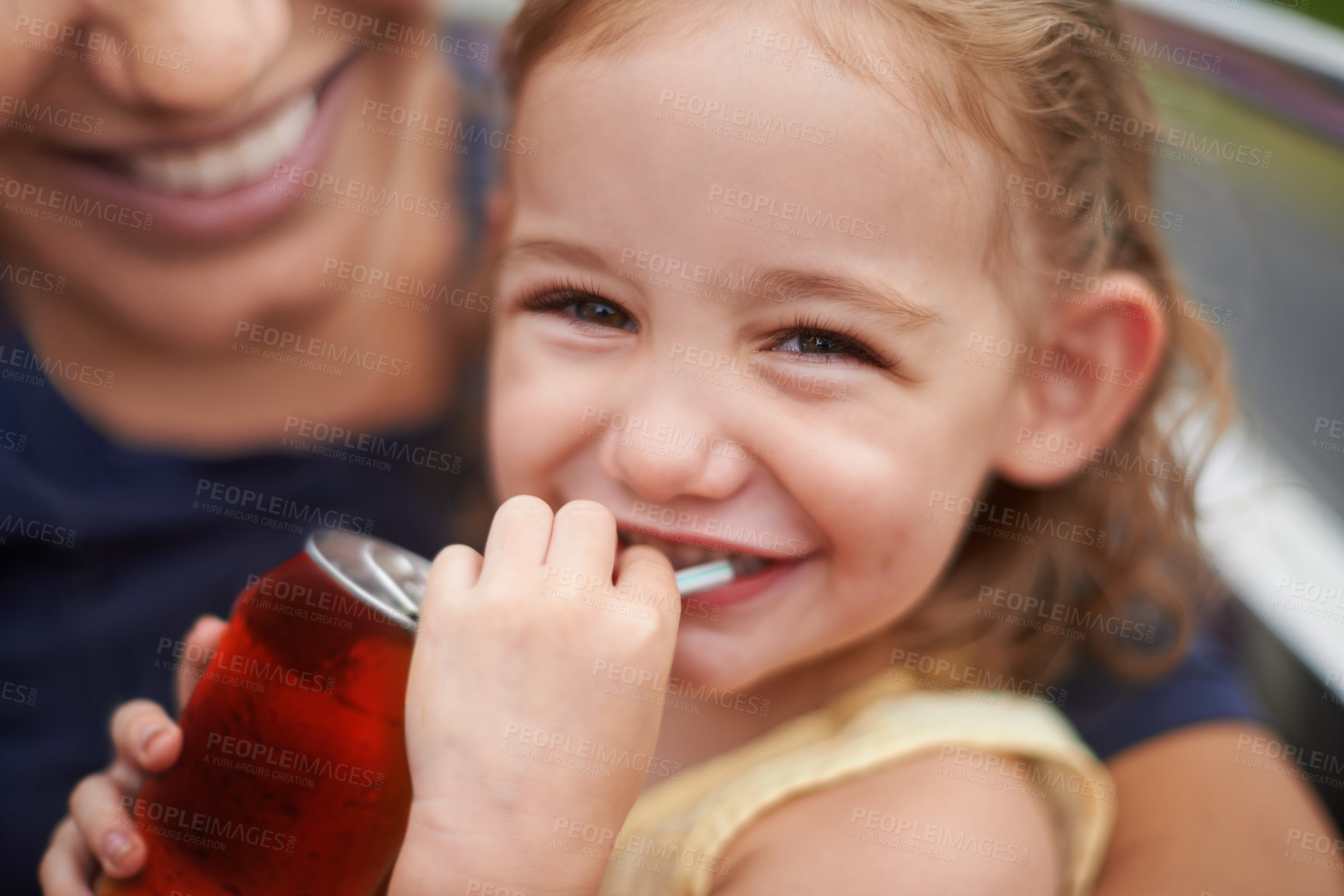 Buy stock photo Portrait of a little girl drinking a soda on her mothers lap