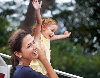 Buy stock photo Cropped shot of a mother lifting her daughter to the sky as she holds her arms open