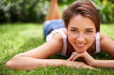 Buy stock photo Woman, portrait and happiness on grass for relax with sunshine, enjoyment or weekend break in summer. Young person, smile or confident on lawn, garden or backyard of home for fresh air in environment