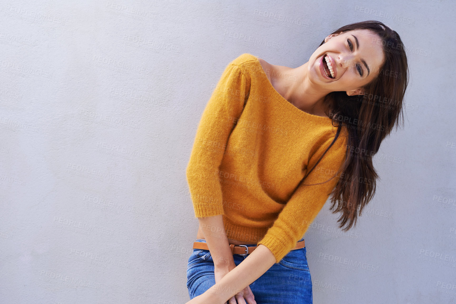 Buy stock photo Portrait, fashion and laughing woman on a wall, funny and happy model isolated on a background mockup space. Smile, excited and young person in casual clothes, trendy and stylish sweater in Italy