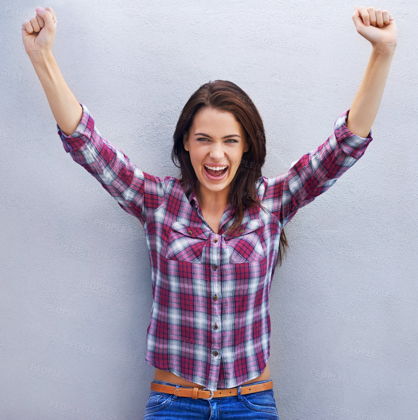 Buy stock photo Shot of an attractive young woman with her arms raised in celebration