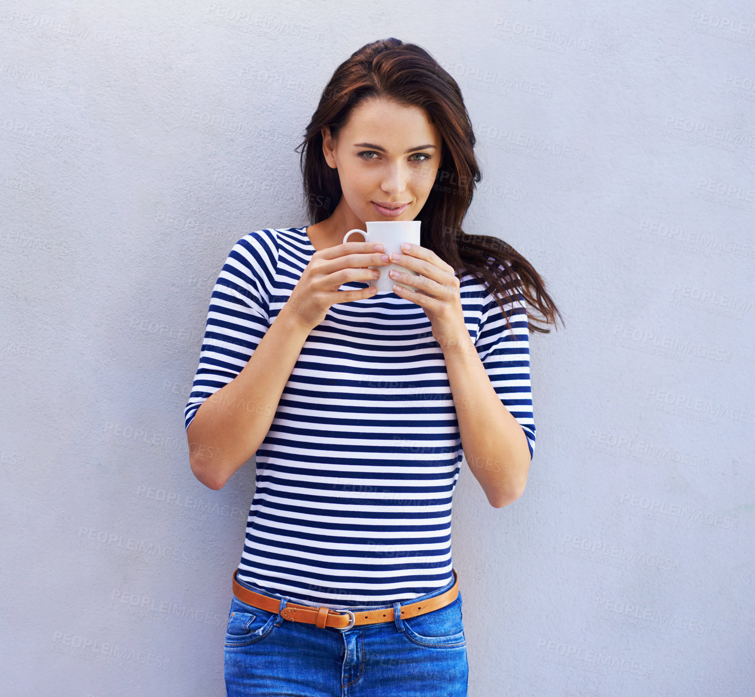 Buy stock photo Portrait of a an attractive woman holding a coffee cup against a gray background