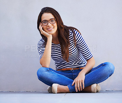 Buy stock photo Happy, fashion and portrait of woman on floor with wall background for casual or trendy style. Smile, model and relax with confident young person legs crossed in glasses for casual clothing outfit