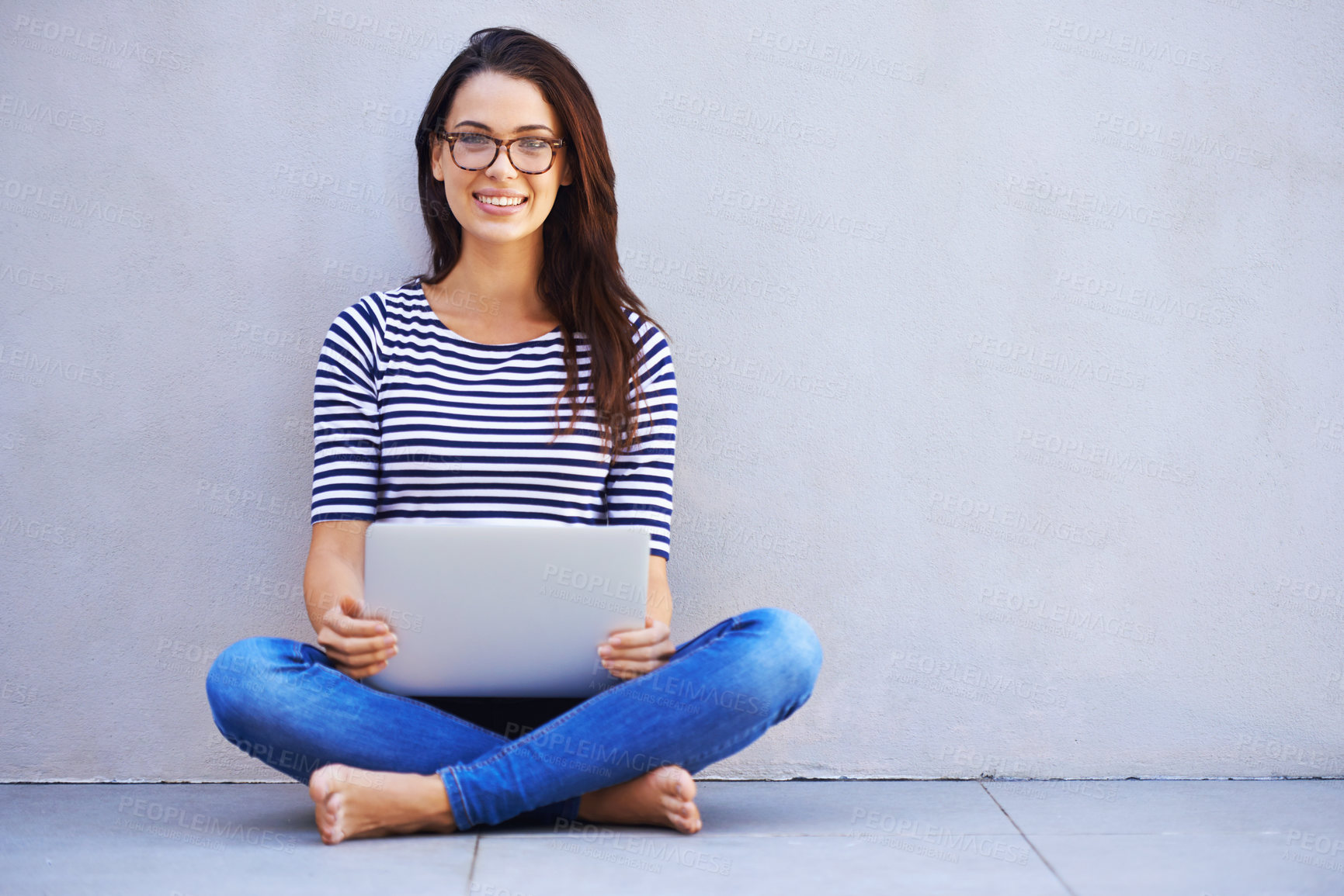 Buy stock photo Full-length shot of an attractive young woman sitting with her laptop