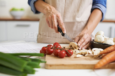 Buy stock photo A young woman chopping vegetables