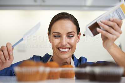 Buy stock photo Baking, cupcakes and woman with spatula and frosting in kitchen for sweet chocolate dessert. Cooking, smile and young female baker working on muffins with culinary tool at home or apartment.