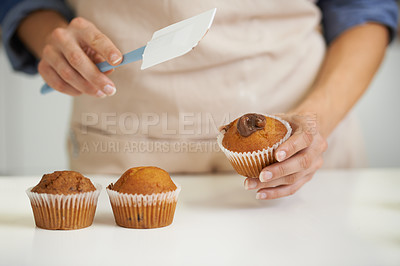 Buy stock photo Hands, person and cupcake with baking, kitchen and spatula for decoration. Baker, muffin and food with countertop, apron and frosting for recipe preparation and recreation or hobby at home or house