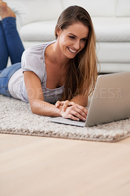 Buy stock photo Woman, smile and laptop on floor with reading for blogging, communication and email on mat in living room of home. Person, happy and technology on ground with relax, streaming show and watching video