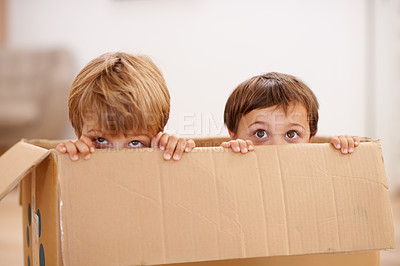 Buy stock photo Box, children and eyes of siblings playing in a house with fun, bonding and hide and seek games. Cardboard, learning and curious kid brothers in a living room with fantasy, imagine or hiding at home