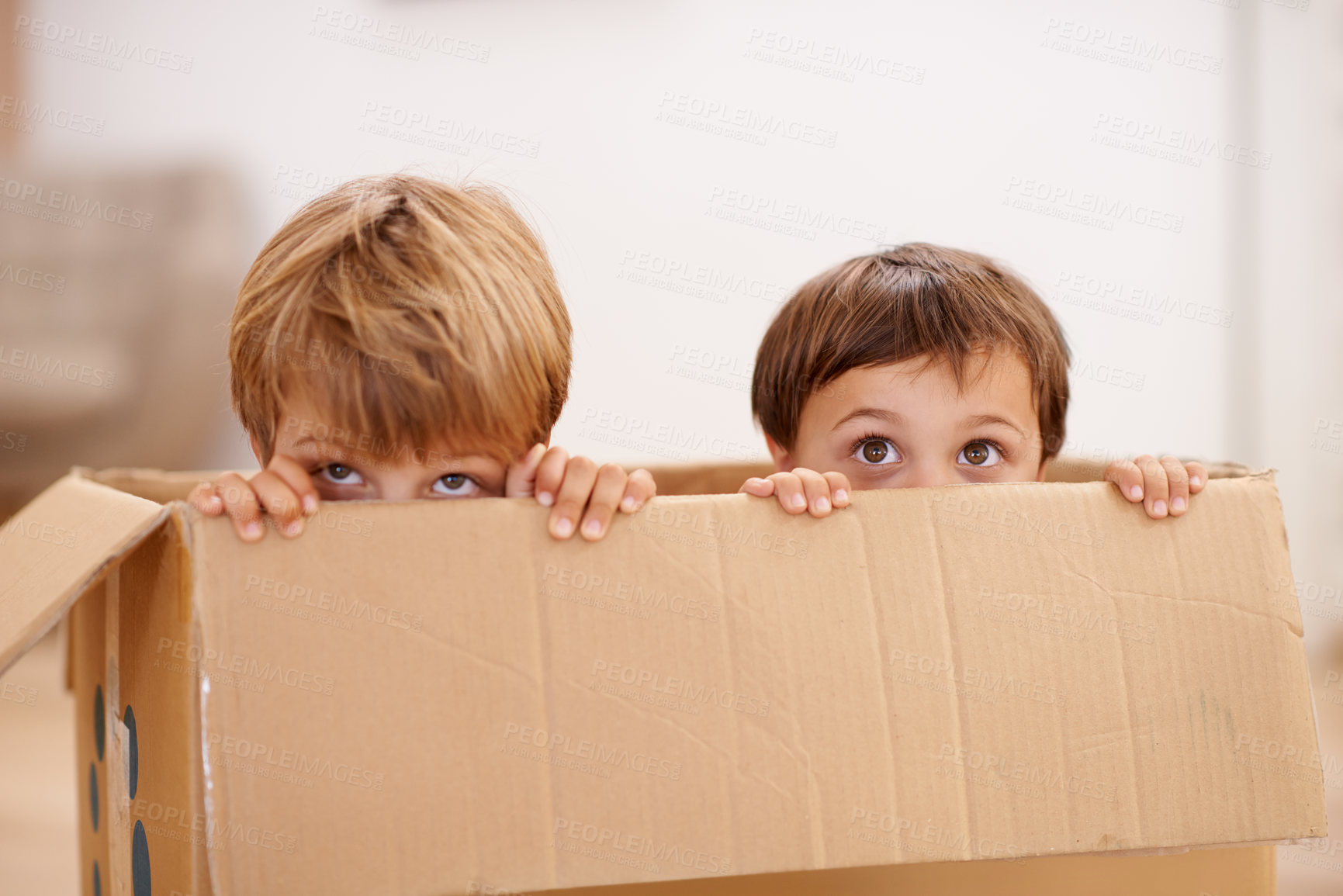 Buy stock photo Box, children and eyes of siblings playing in a house with fun, bonding and hide and seek games. Cardboard, learning and curious kid brothers in a living room with fantasy, imagine or hiding at home