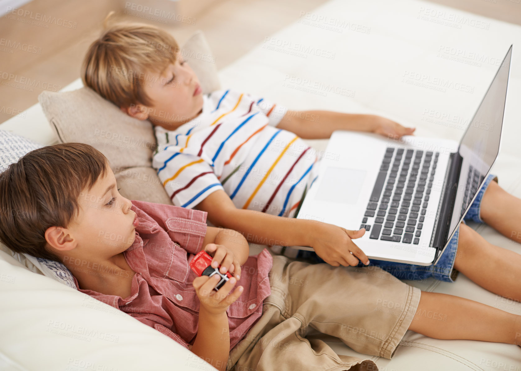 Buy stock photo Laptop, relax and kids on sofa in home, learning and family streaming cartoon on internet together. Computer, children and boys in living room for education, movies or brothers with games in house