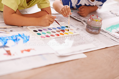 Buy stock photo Children hands, palette and creative with paint brush on floor or playing, hobby and drawing together at home. Kids, motor skills and growth for childhood development with creativity for artwork