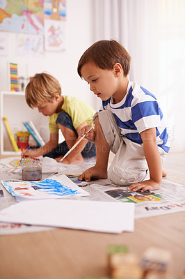 Buy stock photo Boys, paper and painting on floor for creative development, fun activity and education in playroom. Children, bonding and drawing at home for learning, artistic hobby and homework together in house