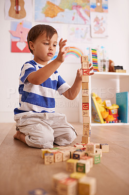 Buy stock photo Home, child or balance with building blocks for playing and learning for development or growth in playroom. Relax, education and playful with activity, young toddler kid and fun games for creativity