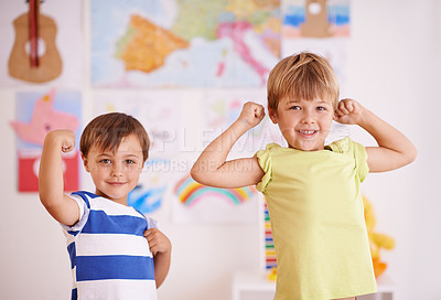 Buy stock photo Two young boys flexing their muscles while standing in their bedroom