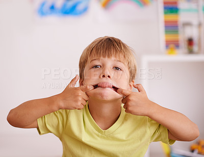 Buy stock photo Boy, child and funny face with tongue out, goofy and playful in playroom, mischievous or naughty with humor. Comic, crazy and silly facial expression for playing, fun and amusement with kid at home