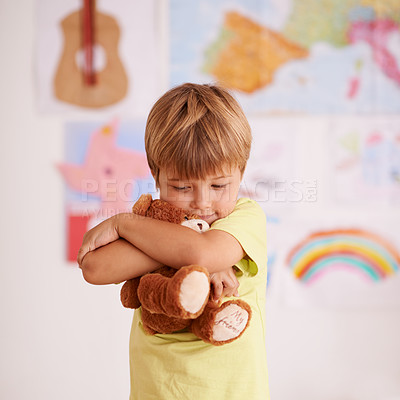 Buy stock photo Child, boy and hug teddy bear, toys for safety and security in childhood with comfort and care in playroom. Peace, calm and affection with stuffed animal, soft and fluffy for love and youth at home