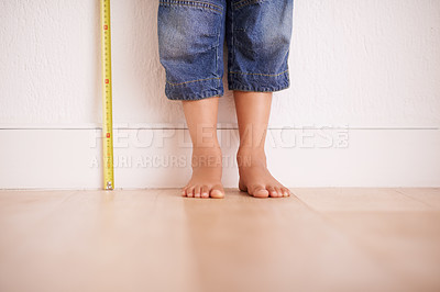 Buy stock photo Cropped shot of a young boy standing next to a tape measure