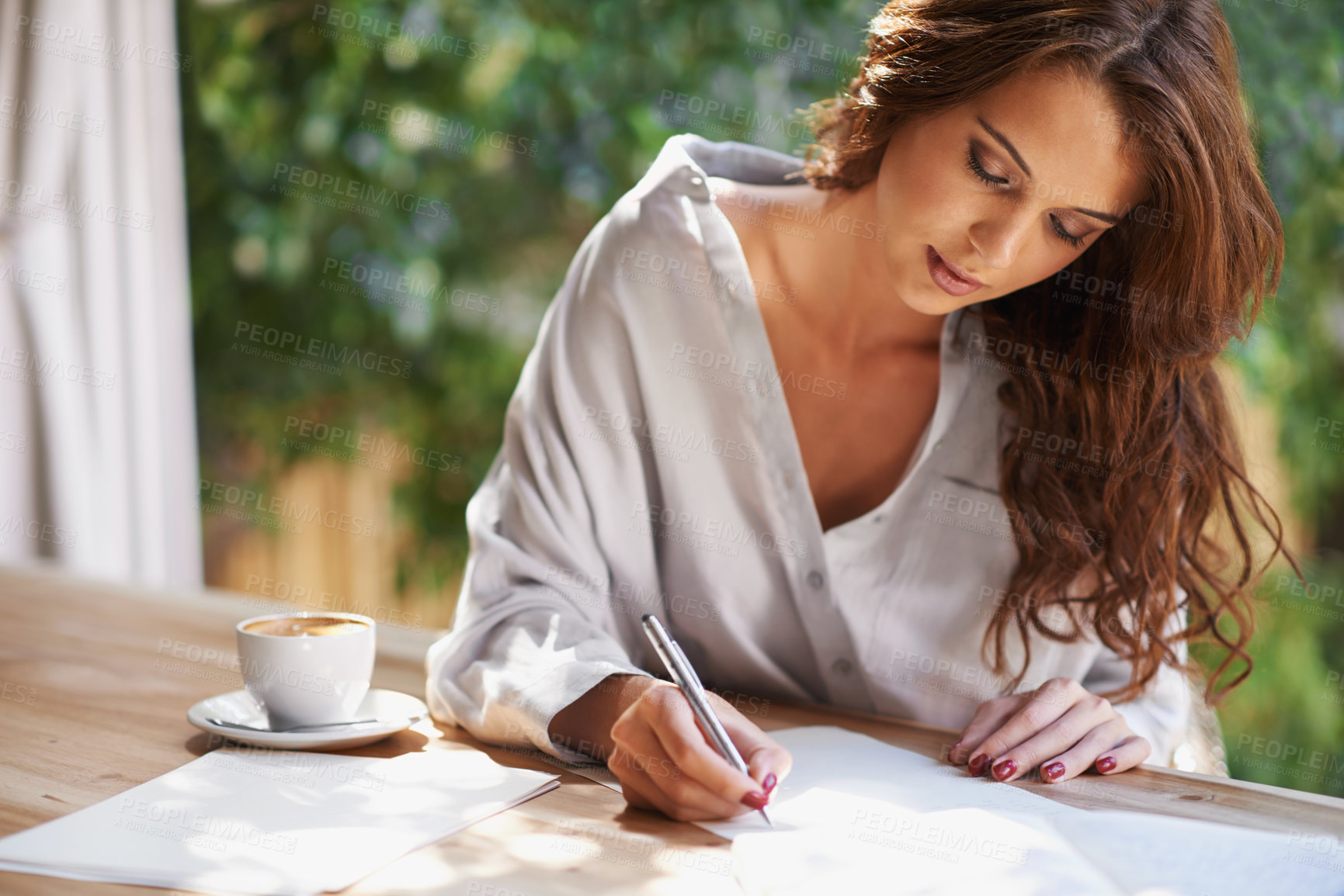 Buy stock photo Shot of an attractive young woman writing in a relaxed environment outdoors