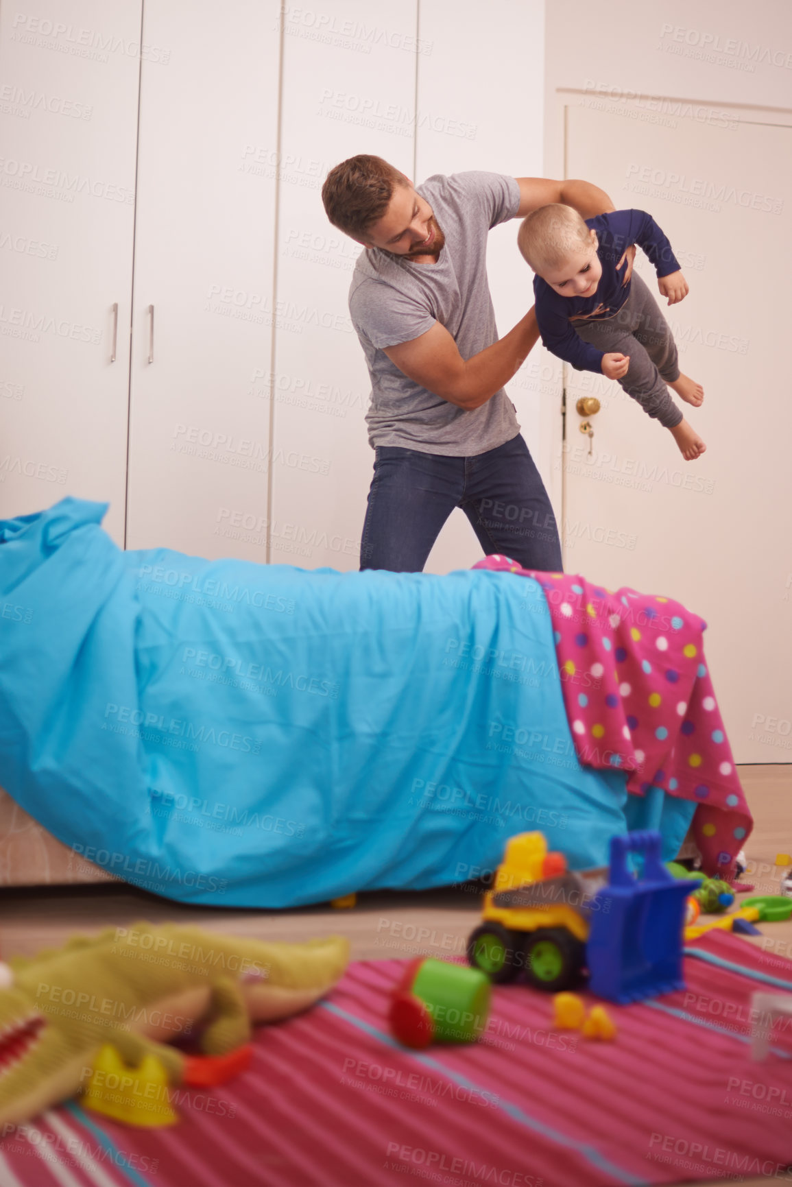 Buy stock photo A young father playing with his young son at home