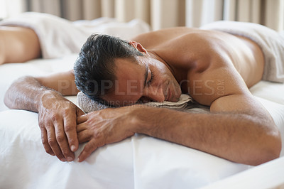 Buy stock photo Relax, massage and man at spa for peace, calm and skincare at luxury resort with eyes closed for wellness. Beauty, therapy or person at salon for body treatment, health or rest on table for service