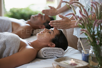 Buy stock photo Hands, head massage and couple in spa to relax on bed for luxury pamper treatment together in hotel. Beauty, facial or zen woman with man at resort or salon for natural healing benefits or skincare