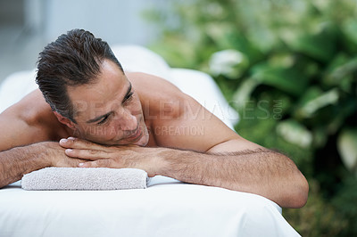 Buy stock photo Outdoor, spa and man relax for massage on table in hotel, calm and care for body in vacation. Holiday, luxury and male person on break for weekend, accommodation and lodge with treatment for skincare