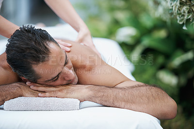 Buy stock photo Luxury, spa and man relax for massage on table in hotel, calm and care for body in vacation. Holiday, outdoor and male person on break for weekend, accommodation and lodge with treatment for skincare