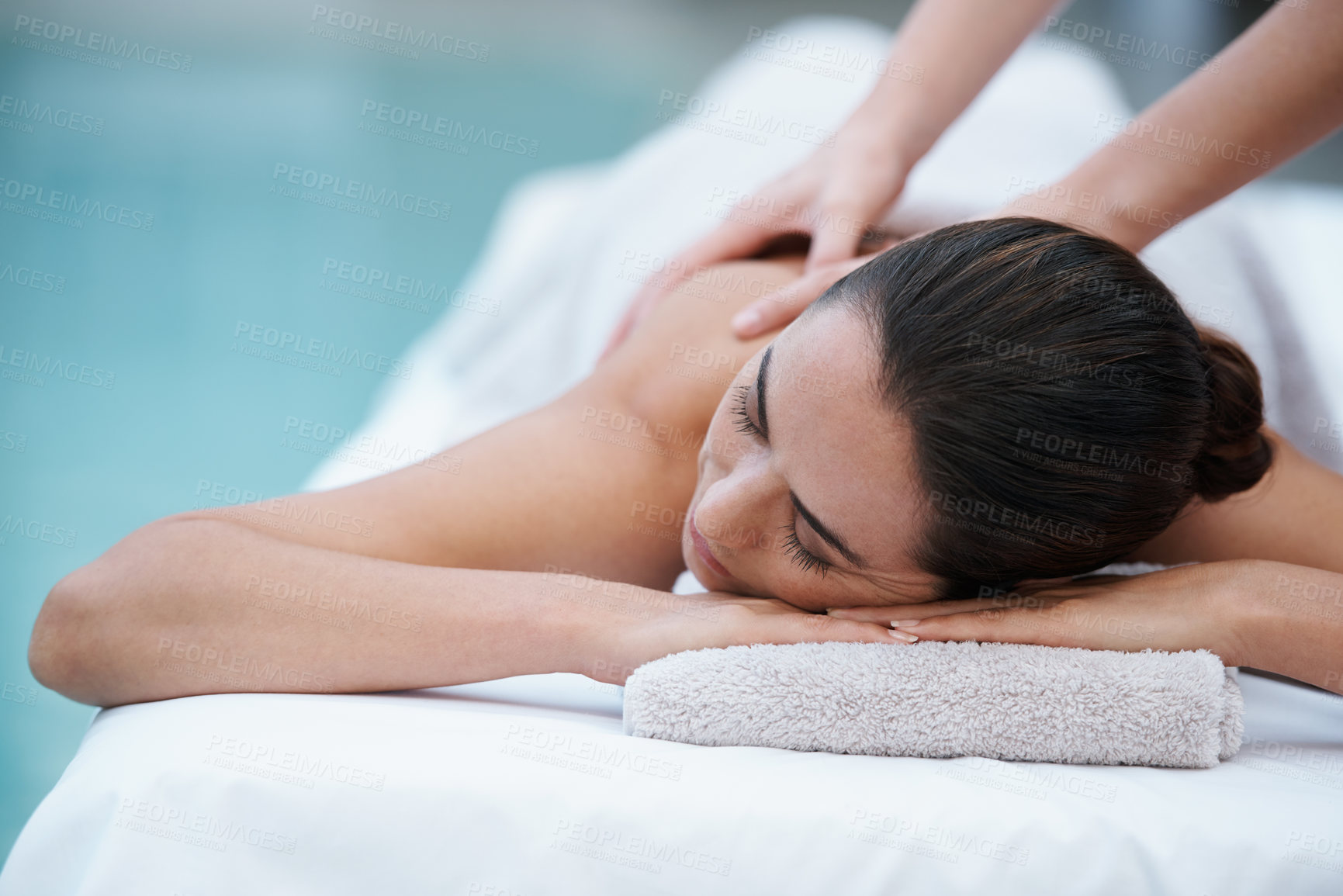 Buy stock photo Shot of a woman enjoying a massage beside a pool