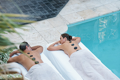 Buy stock photo High angle shot of a couple enjoying a hot stone massage