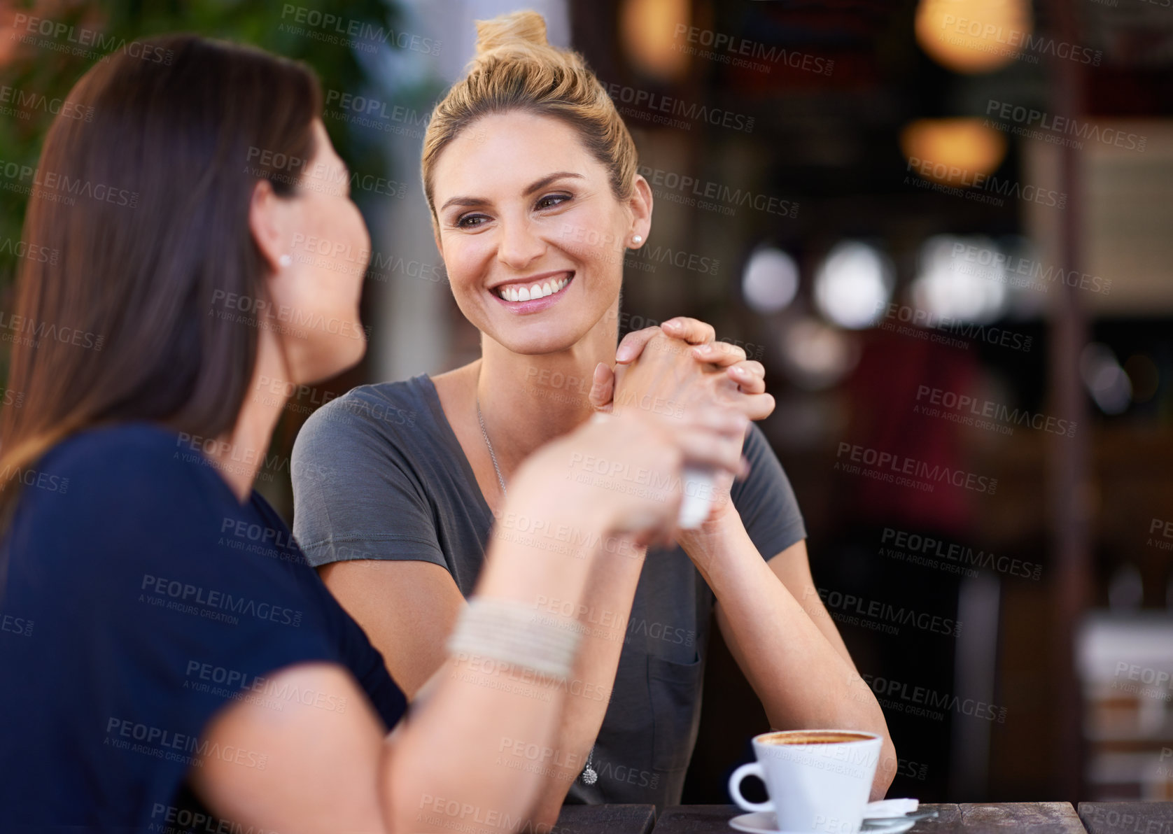 Buy stock photo Two attractive women sitting outside a cafe
