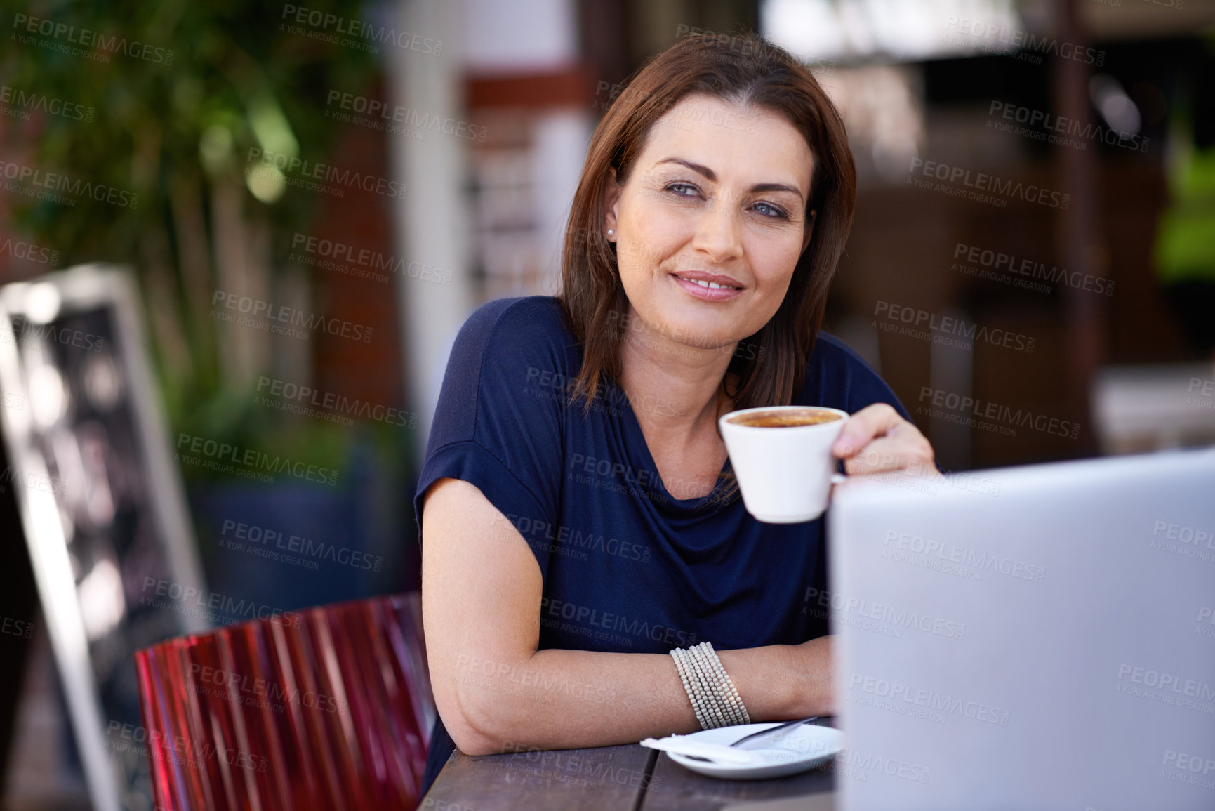Buy stock photo Shot of an attractive woman using her laptop at a coffee shop
