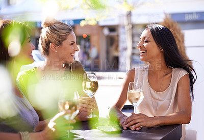 Buy stock photo Cropped shot of three women enjoying a glass of white wine at a sidewalk cafe