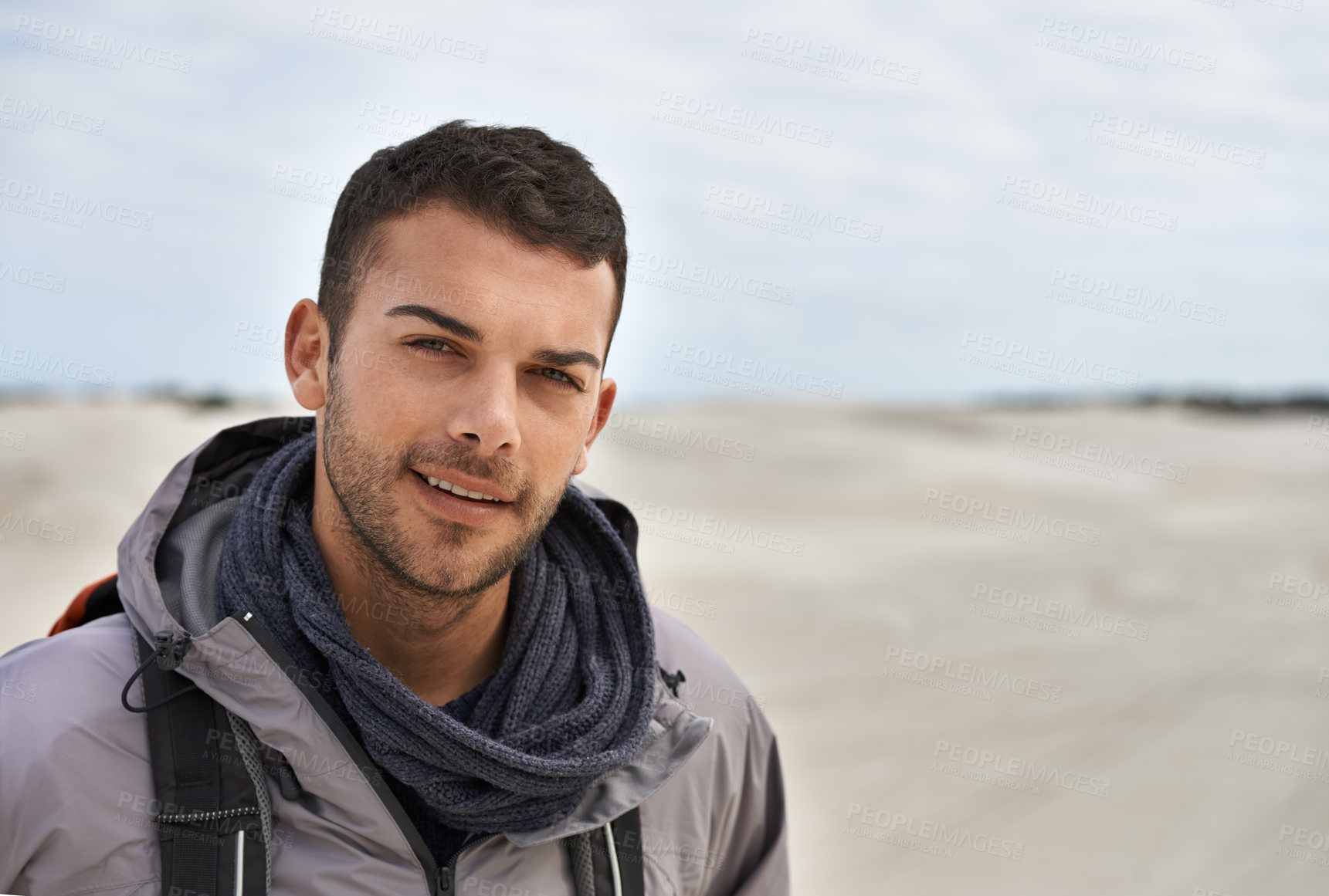 Buy stock photo Portrait of a young male hiker walking along the sand dunes