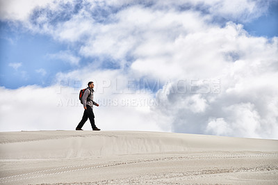 Buy stock photo Hike, dunes and male in nature for adventure, walk and desert landscape for travel or exercise. Fitness, holiday and nomad man person in Sahara terrain, outdoor or freedom in dry climate and scenery
